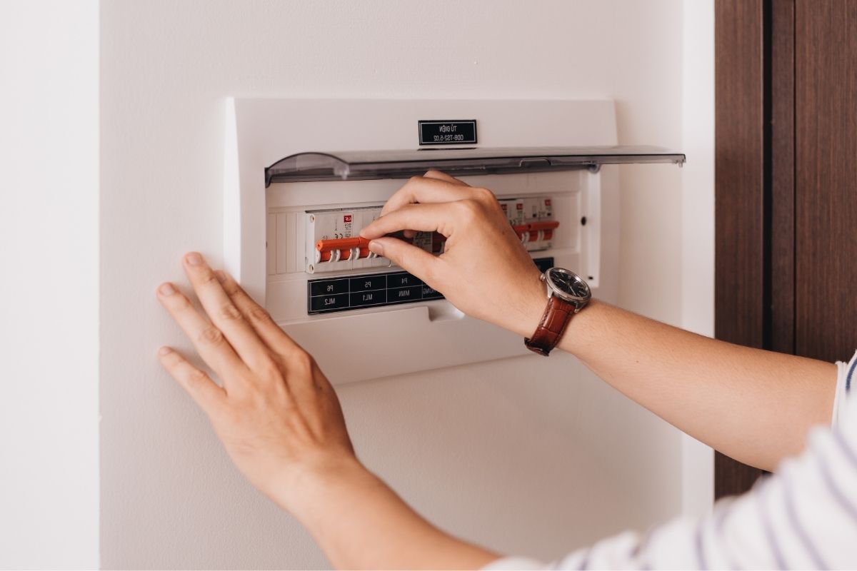 home owner holding the switch of switchboard in High Wycombe home